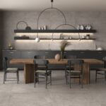 Eleganza e funzionalità si incontrano in questa sala da pranzo dal design moderno. Le tonalità di grigio e sabbia, unite al pavimento in gres porcellanato, creano un ambiente sofisticato e accogliente. Il tavolo, posizionato al centro, e la cucina attrezzata offrono il massimo della praticità senza rinunciare alla bellezza. Un'ottima scelta per chi desidera un ambiente versatile e di classe.